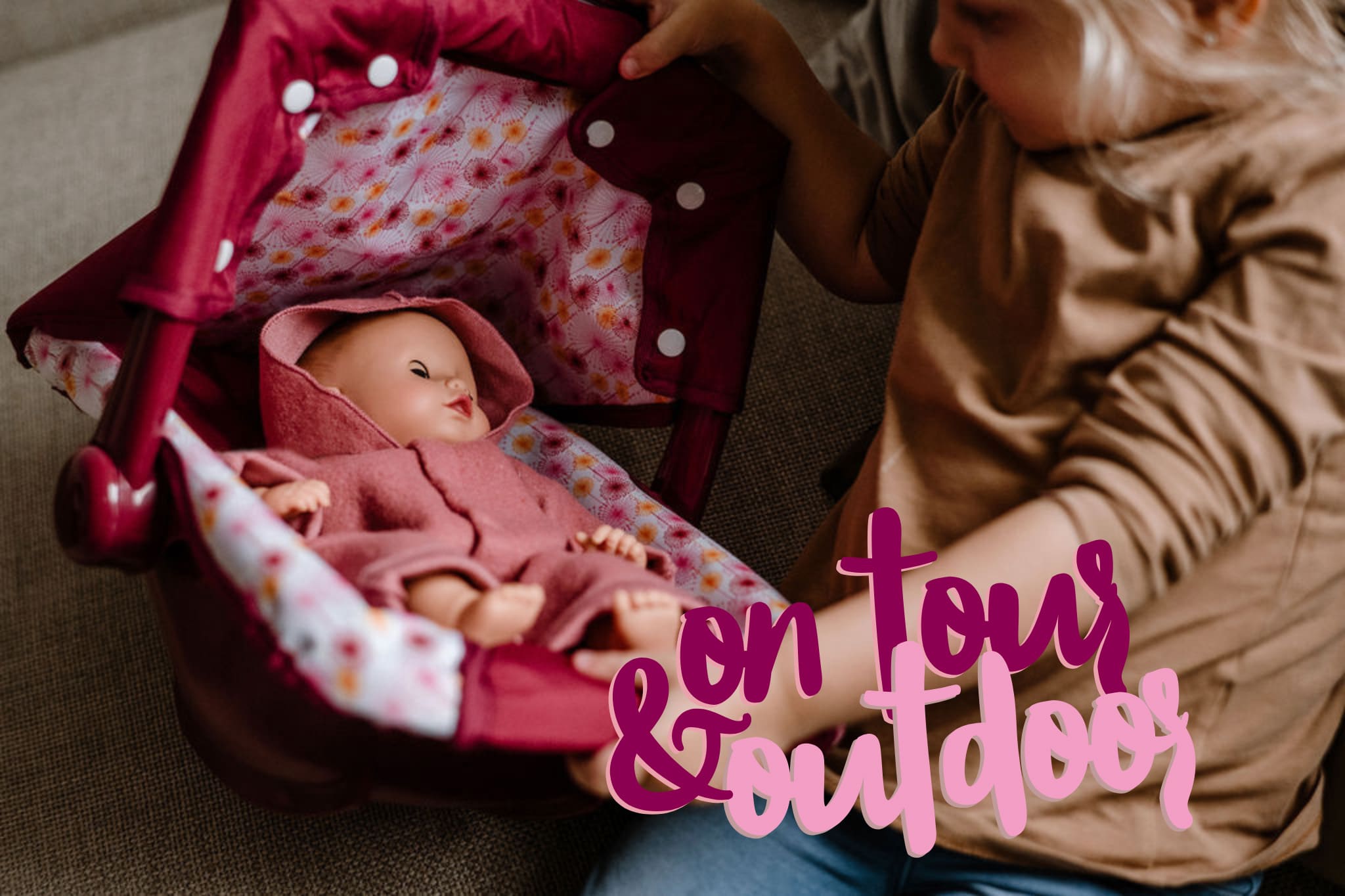 Child plays with 33 cm baby doll in a doll carrier
