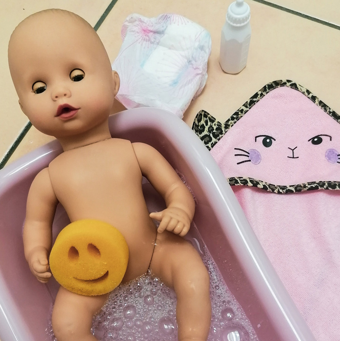 Aquini Badepuppe in rosaner Badewanne , Windel, Fälschen und Handtuch stehen bereit