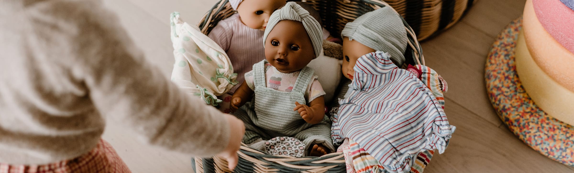 Kind laueft zu einer Kiste mit Puppen von Goetz