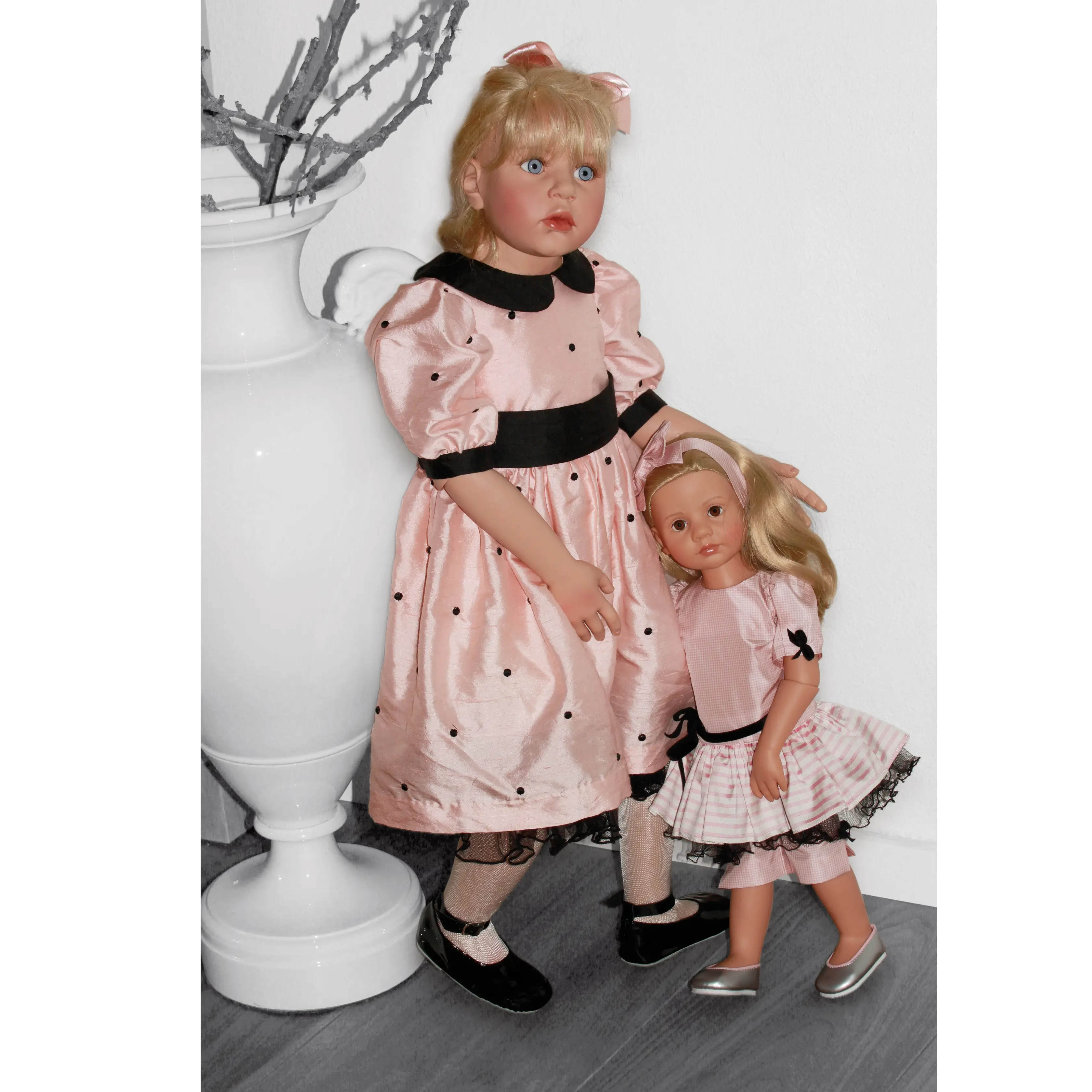 Kuenstlerpuppe 87 cm von Hildegard Guentzel in rosa Seidenkleid mit schwarzen Tupfen, blondem Haar mit schwarzer Schleife. Dazu eine blonde Hannah Stehpuppe von Goetz