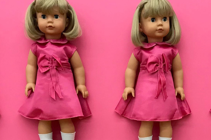 Mehrere blonde Stehpuppen in pinken Kleidern als Teil eines Theaterbuehnenbilds