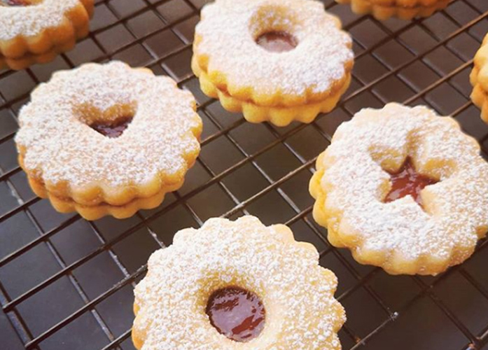 Weihnachtskekse mit Marmeladenfüllung auf Backrost