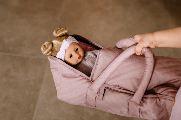 Tragebettchen Goetz blonde Babypuppe mit Schlafaugen in rosa Tragebettchen