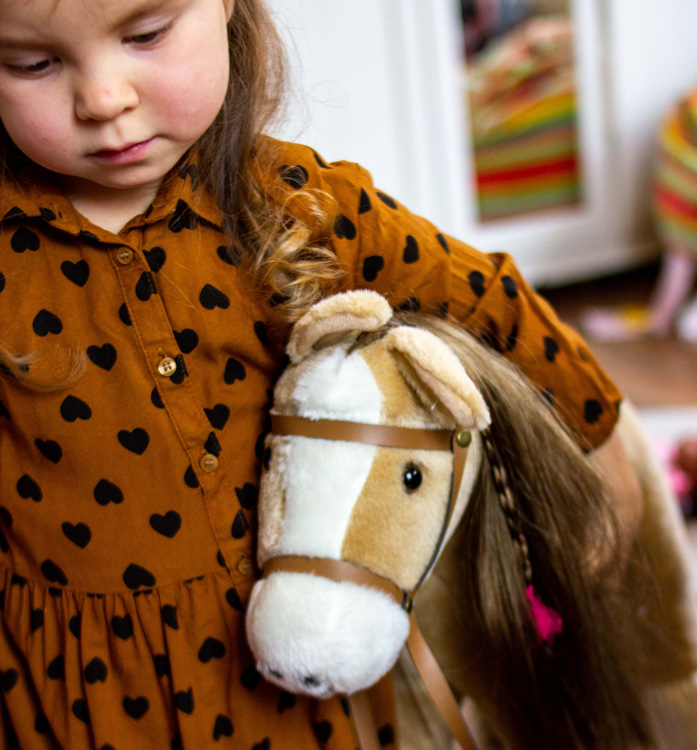 Kind hat Kämmpferd im Arm