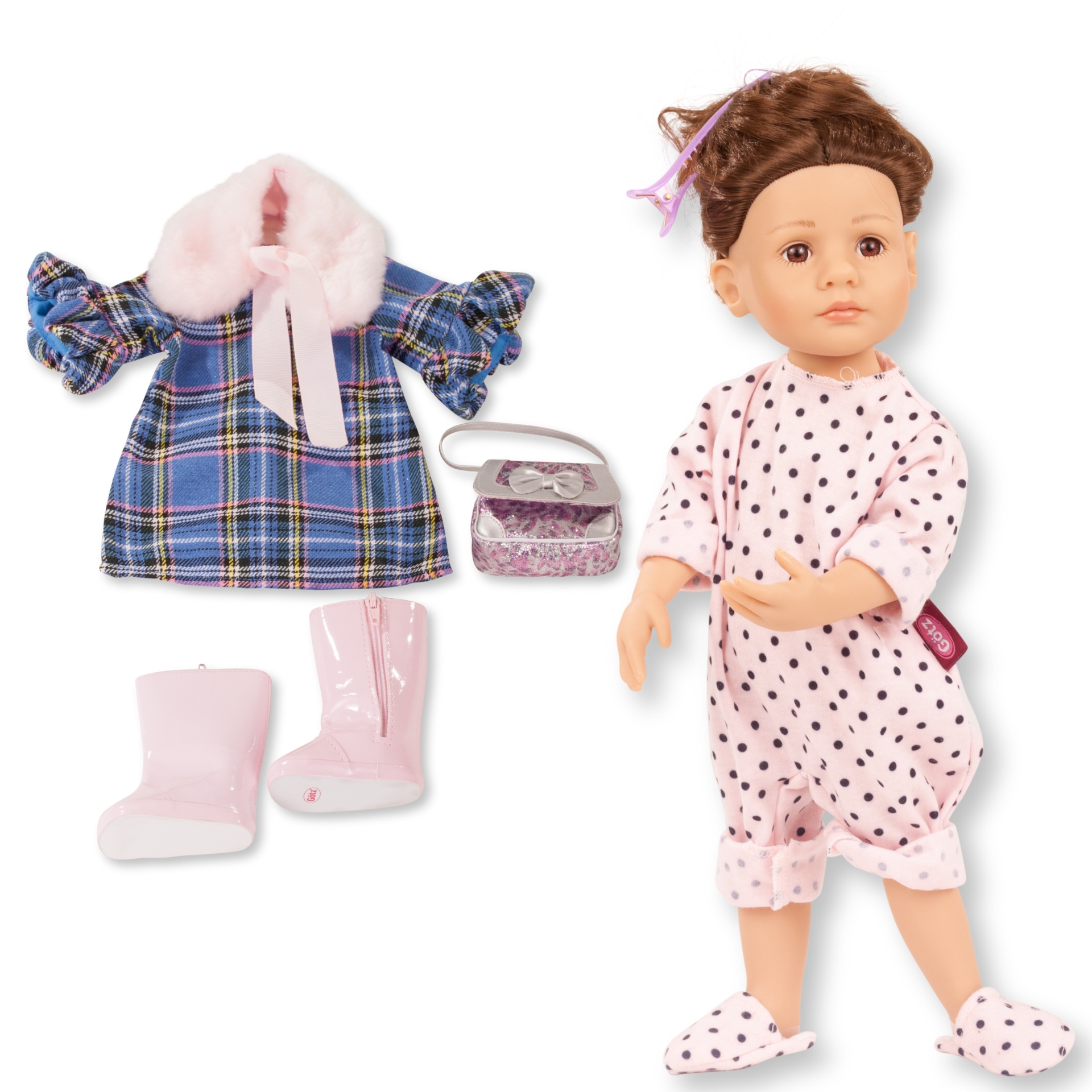 Stehpuppe Gr. 36 cm im Onesie mit Hausschuhen, einem Karo-Kleid mit Plüschschal, einer Handtasche mit Glitzer und rosè farbenen Stiefeln. Die Puppe hat langes braunes Haar und braune Augen.