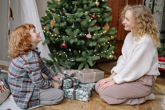 Mutter-und-kind-sitzen-vor-dem-weihnachtsbaum