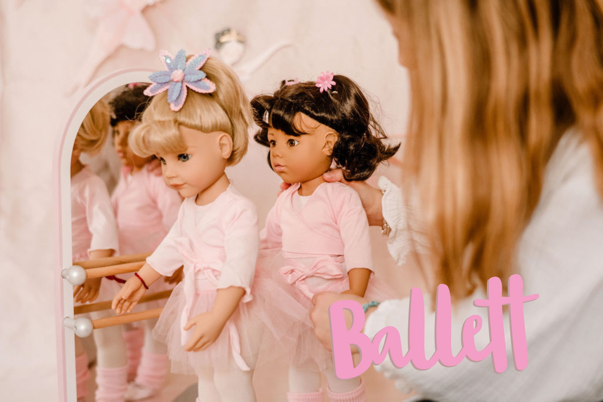 Kind spielt mit einer schwarzhaarigen und blonden 50 cm grossen Ballettstehpuppe an der Ballettstange