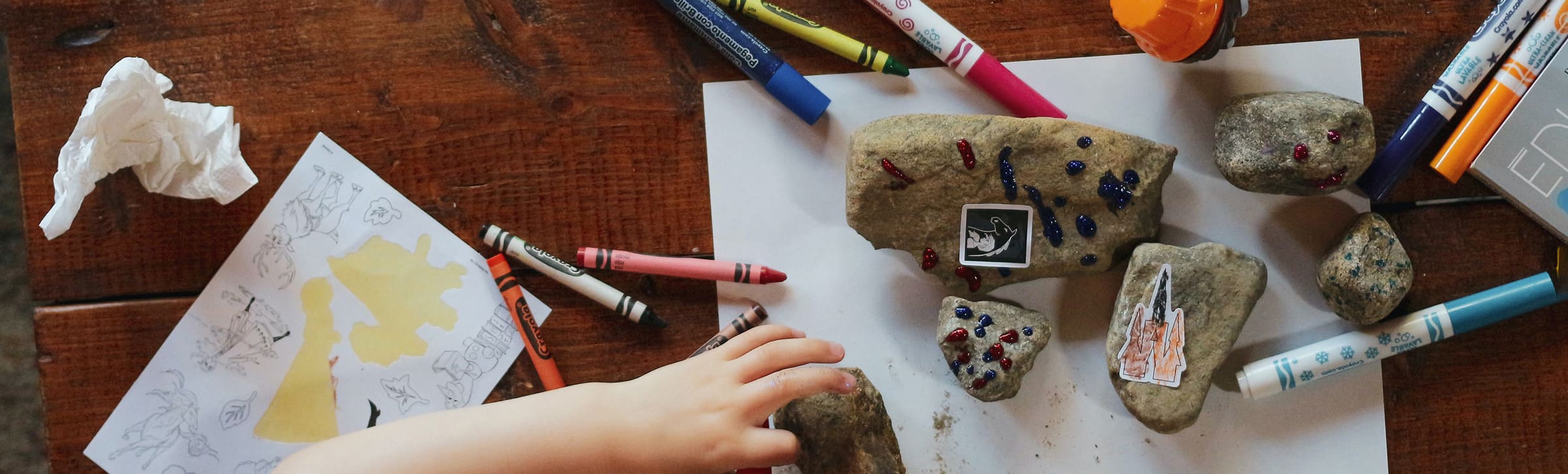 Basteltisch mit verschiedenen Utensilien wie Malstiften und Blaettern
