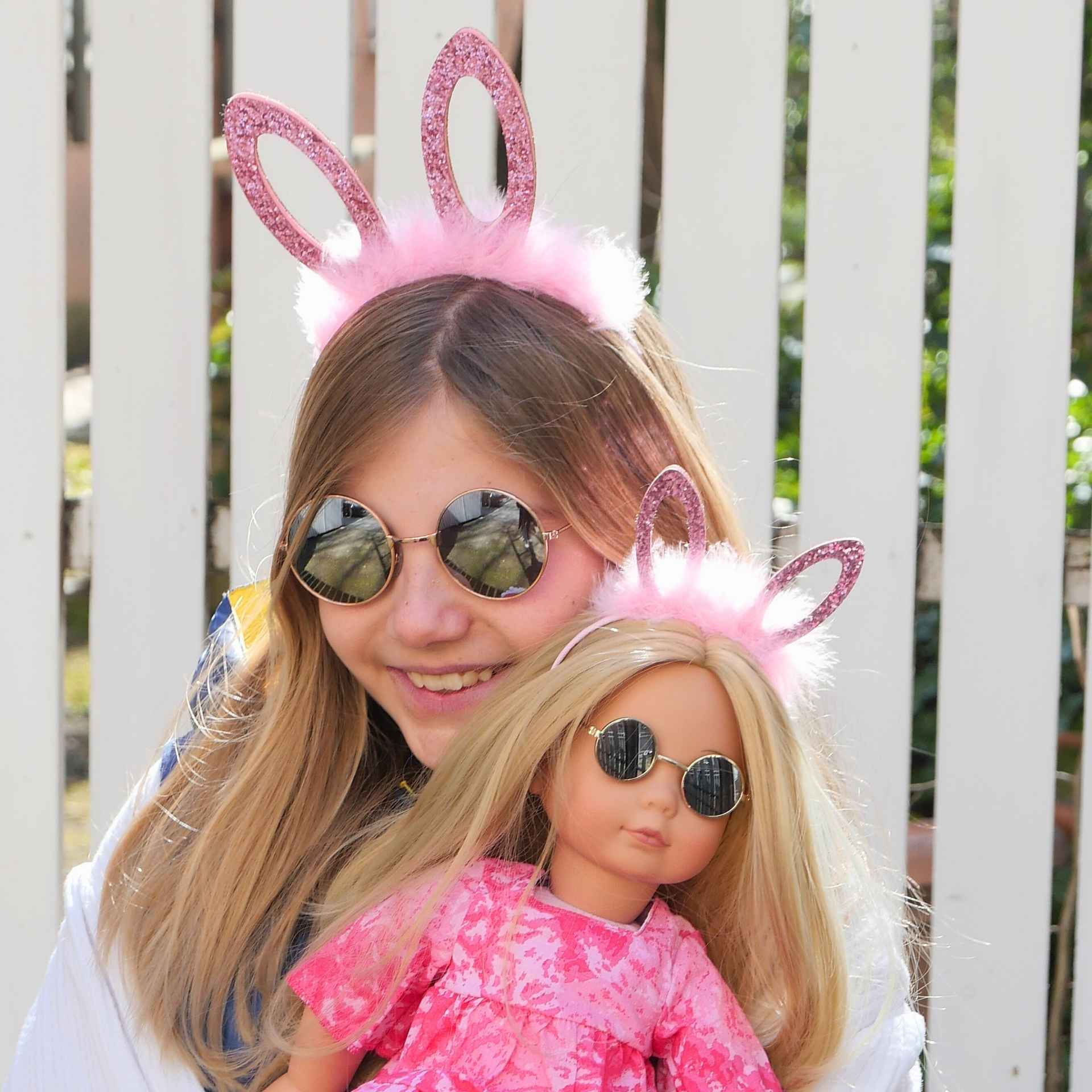 Kind und blonde Stehpuppe im Partnerlook mit Hasenhaarreif und Sonnenbrille