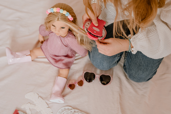 Hannah Be My Mini Me Goetz Kind verziert die Haare einer 50 cm großen Stehpuppe mit blonden Haaren und rosa Kleid mit einem Schmuck-Applikator und Glitzersteinchen