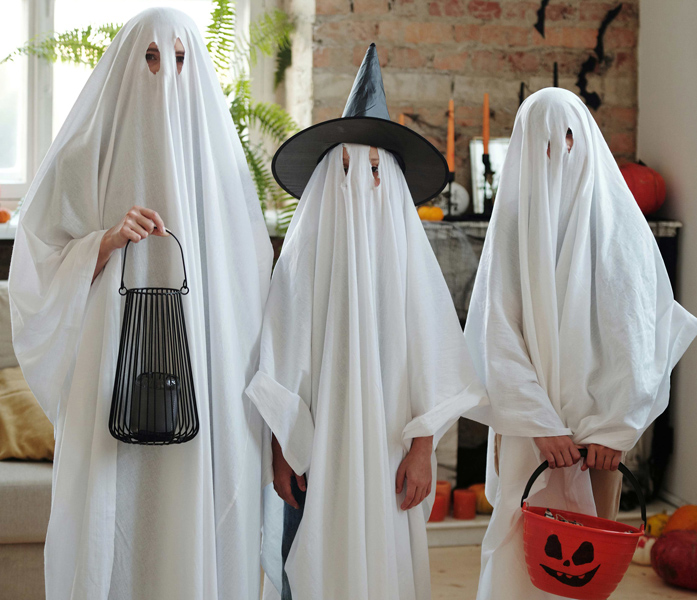 Drei Kinder als Gespenster verkleidet