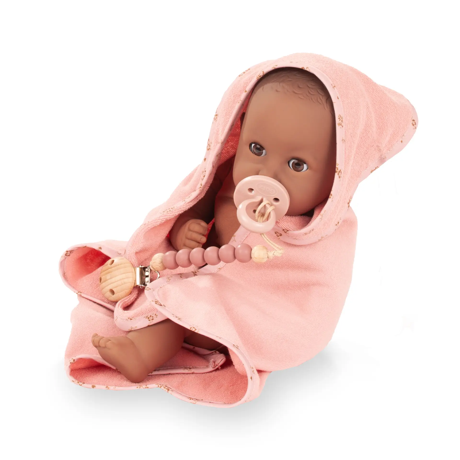 Badepuppe Gr. 33 cm in braunem Vinyl, ohne Haare mit braunen Schlafaugen. Sie ist in einem Kapuzentuch mit  Schnuller und Schnullerkette von Goetz