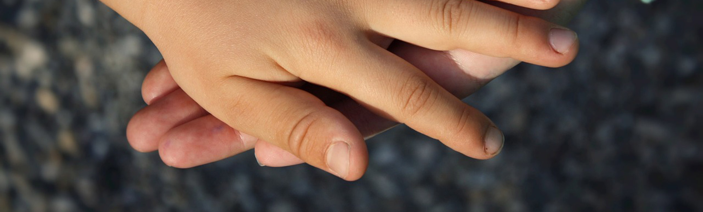 Zwei Kinderhaende liegen uebereinander