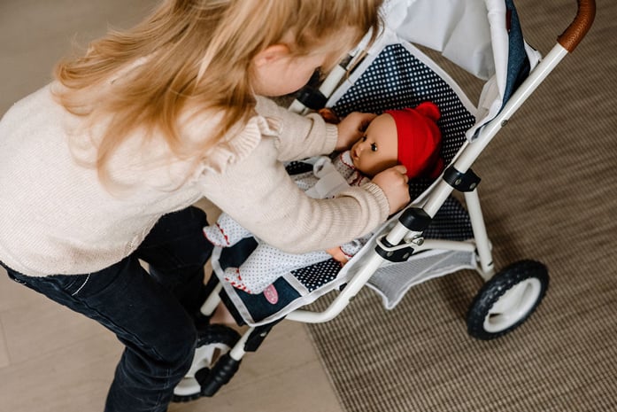 Puppenbuggy Denim Goetz Kind spielt mit 33 cm grosser Babypuppe und Puppenbuggy