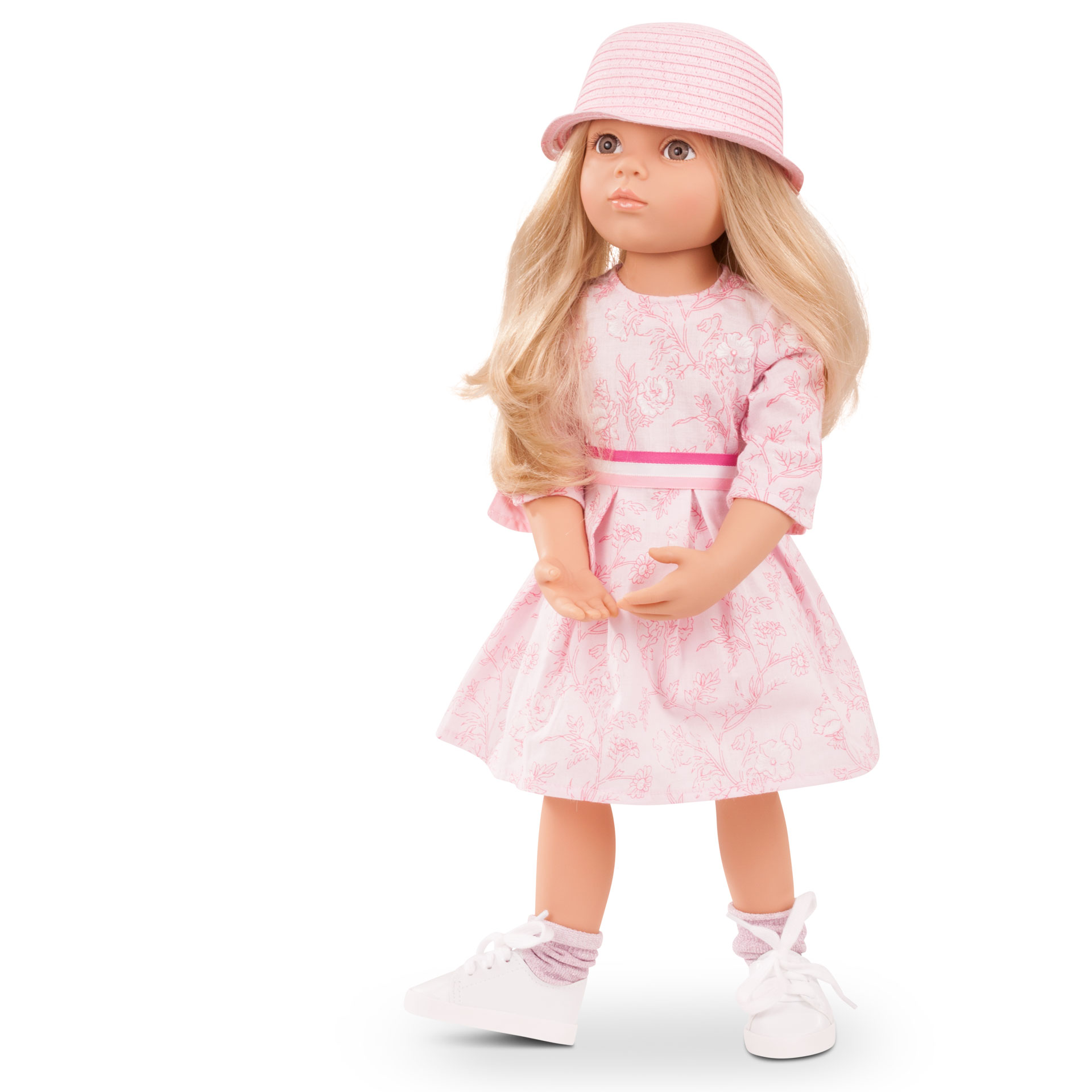 Stehpuppe Gr. 50 cm mit blondem Haar und grauen Augen. Sie traegt ein rosa-weisses Sommerkleid mit Hut und Sneakers mit Soeckchen von Goetz