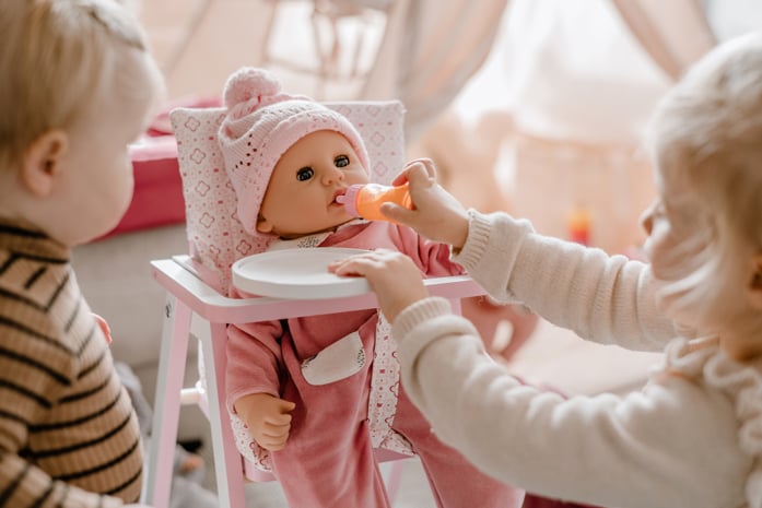 Nachhaltiger Spielspaß Goetz Kind fuettert eine 48 cm große Babypuppe mit einem