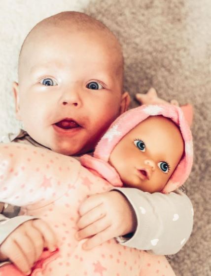 Kind haelt Erstlingspuppe im Arm