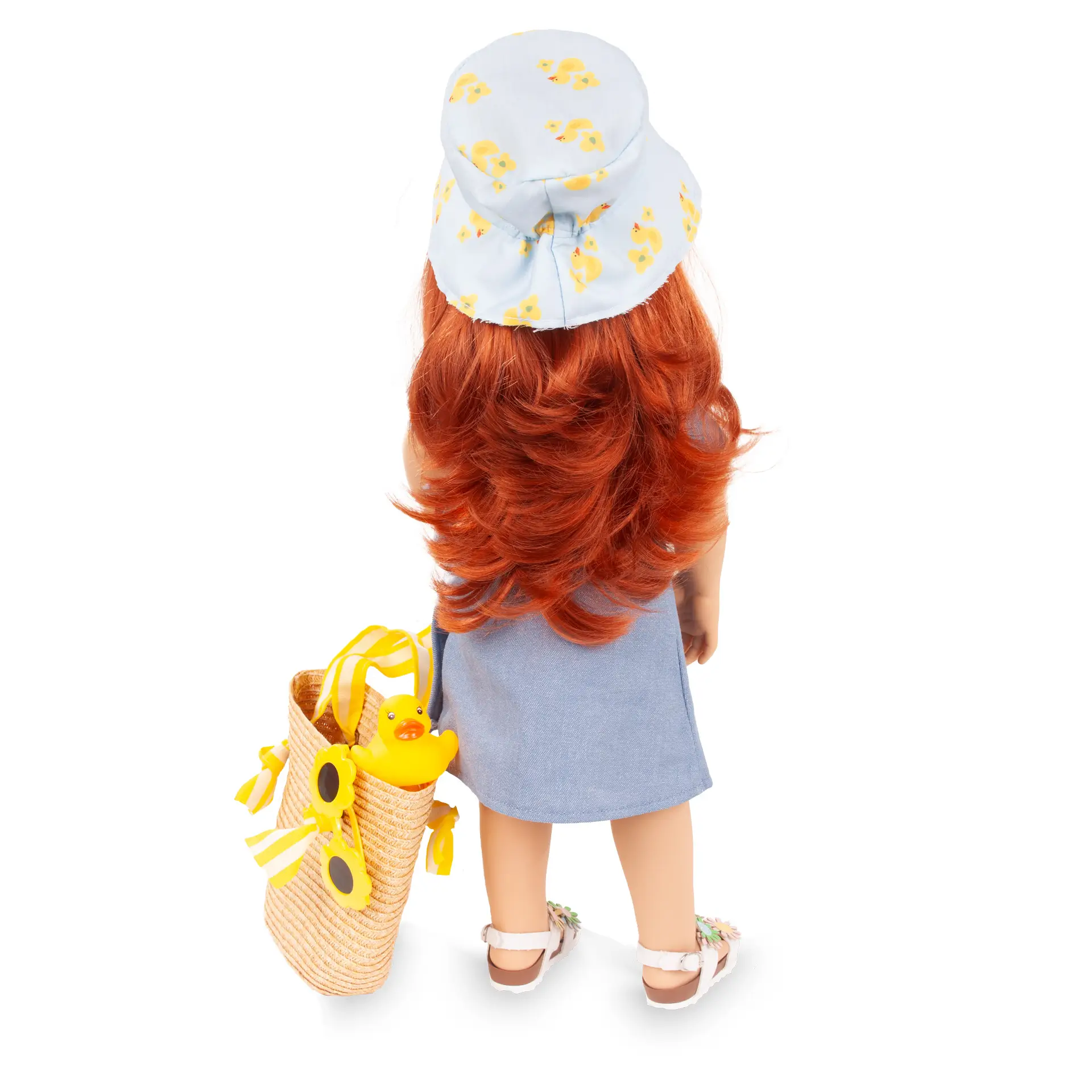 Rueckansicht von Stehpuppe Gr. 45 cm mit braunem langen Haar und braunen Augen in blauem Wickelkleid mit Basttasche, Blumensandalen, einer Cappy, Badeente und Sonnenbrille von Goetz
