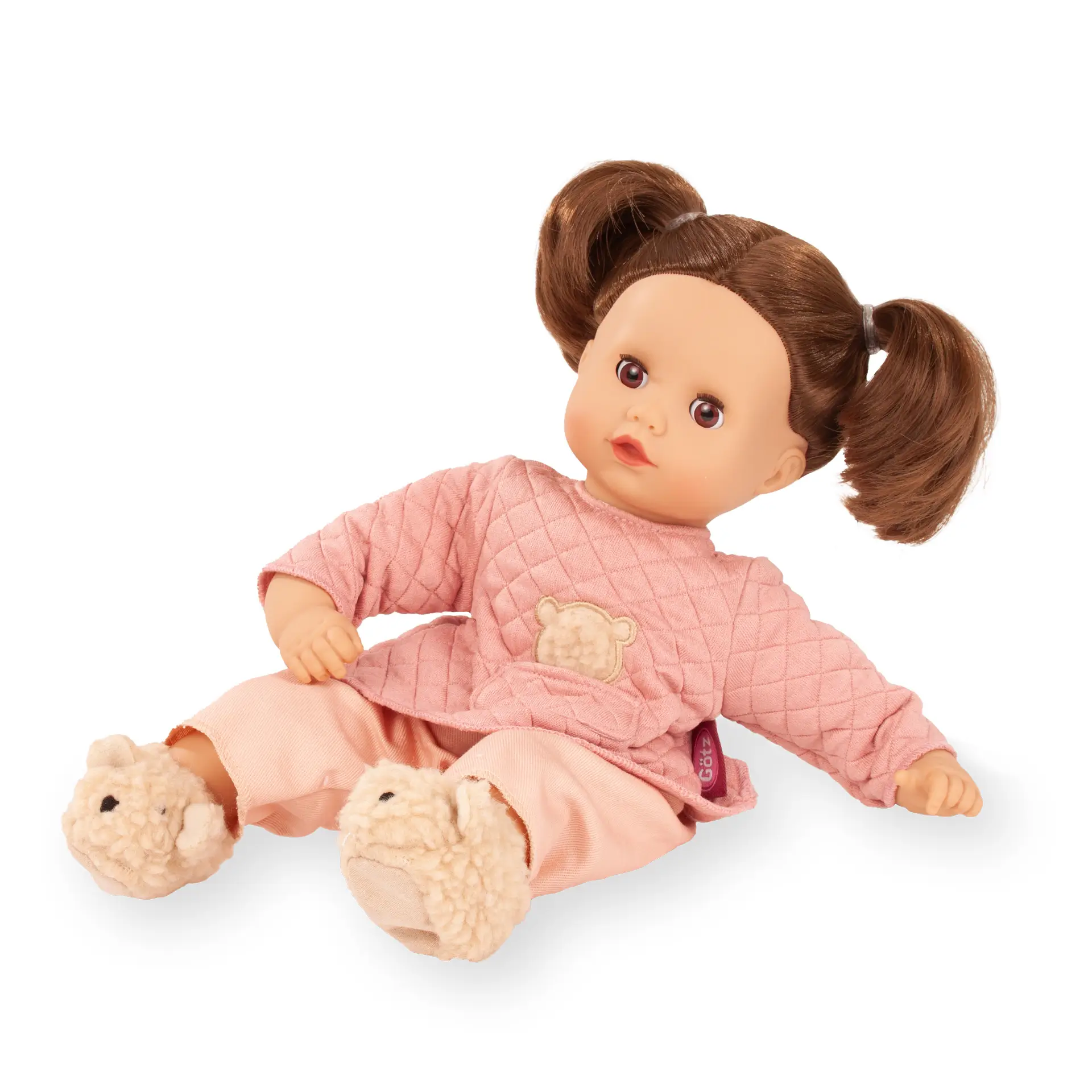 Babypuppe Gr. 33 cm mit braunem Haar und braunen Schlafaugen. Sie traegt einen 2-Teiler mit Teddyapplikation, Plueschhausschuhen mit Baerengesicht von Goetz
