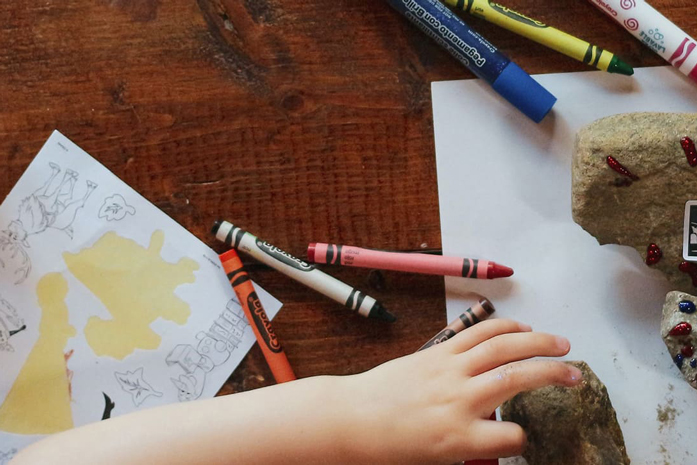 Basteltisch mit verschiedenen Utensilien wie Malstiften und Blaettern