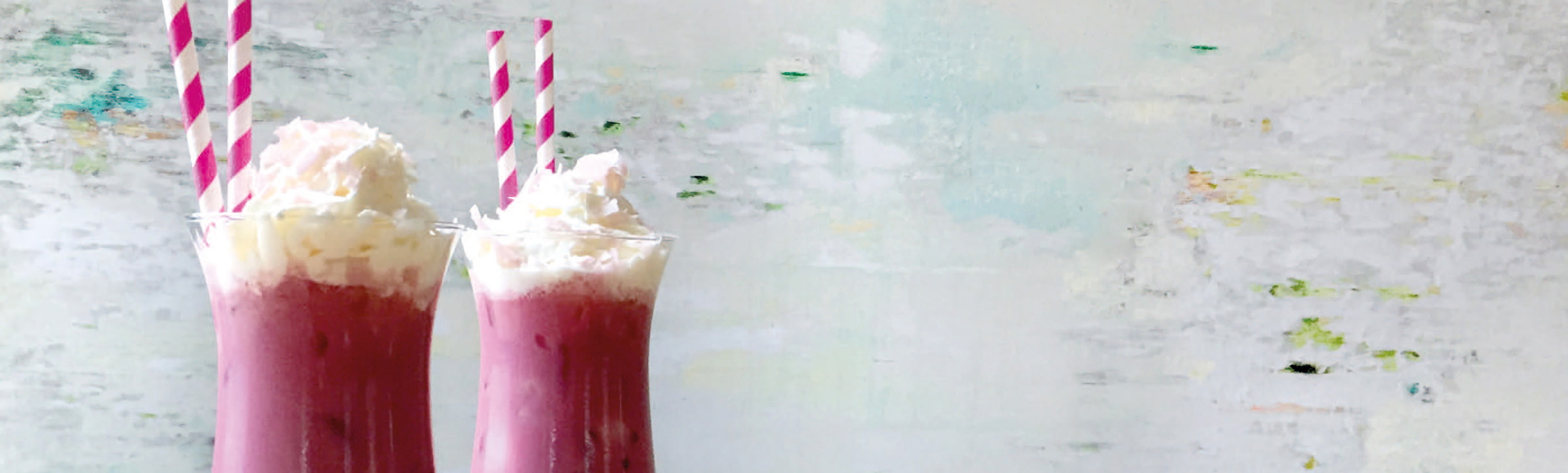 Cocktail im Glas mit Strohhalm und Sahnehaube