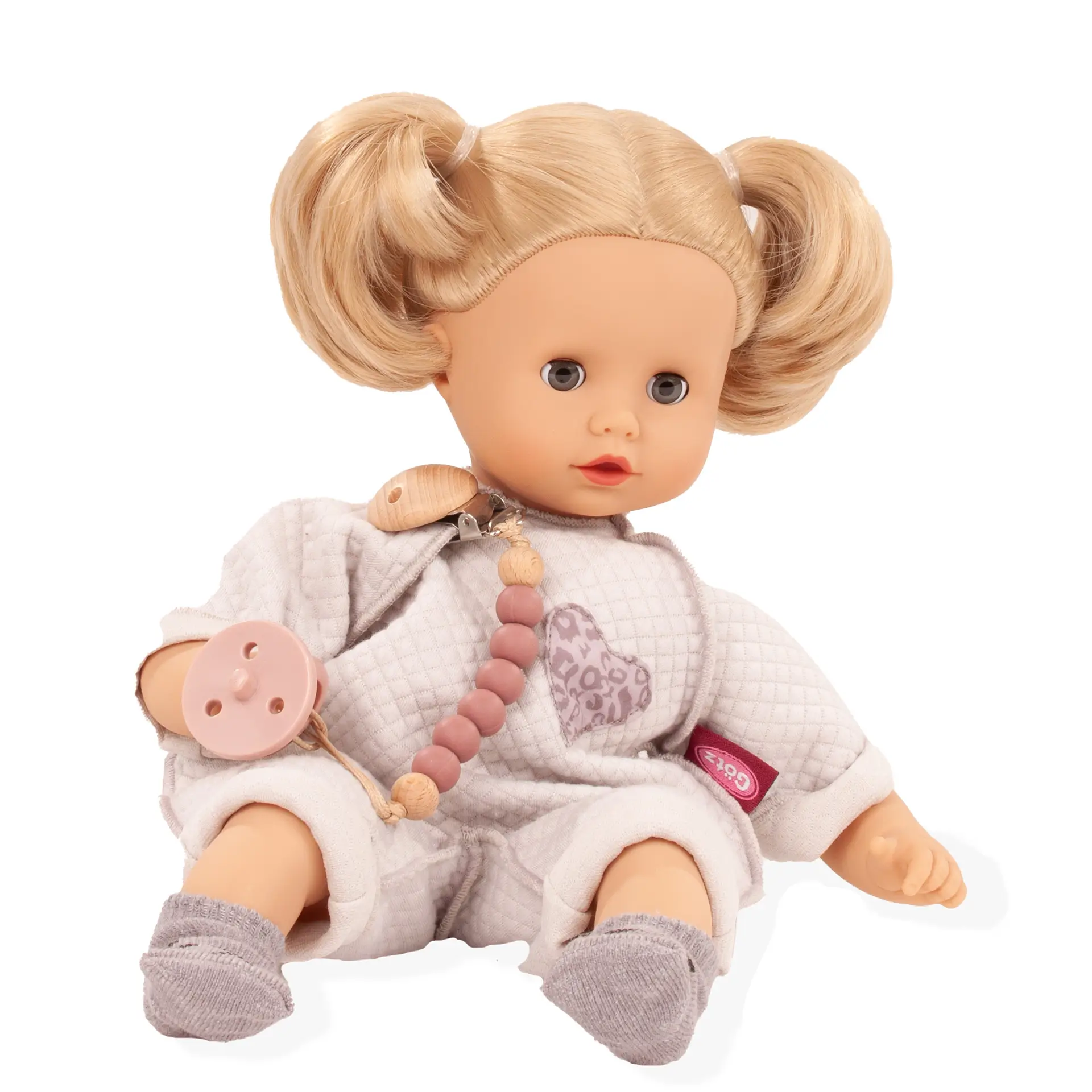 Babypuppe Gr. 30-33 cm mit blondem Haar und blauen Schlafaugen. Sie traegt einen hellgrauen Anzug, grauen Soeckchen, eine Schnullerkette und einen Schnuller von Goetz