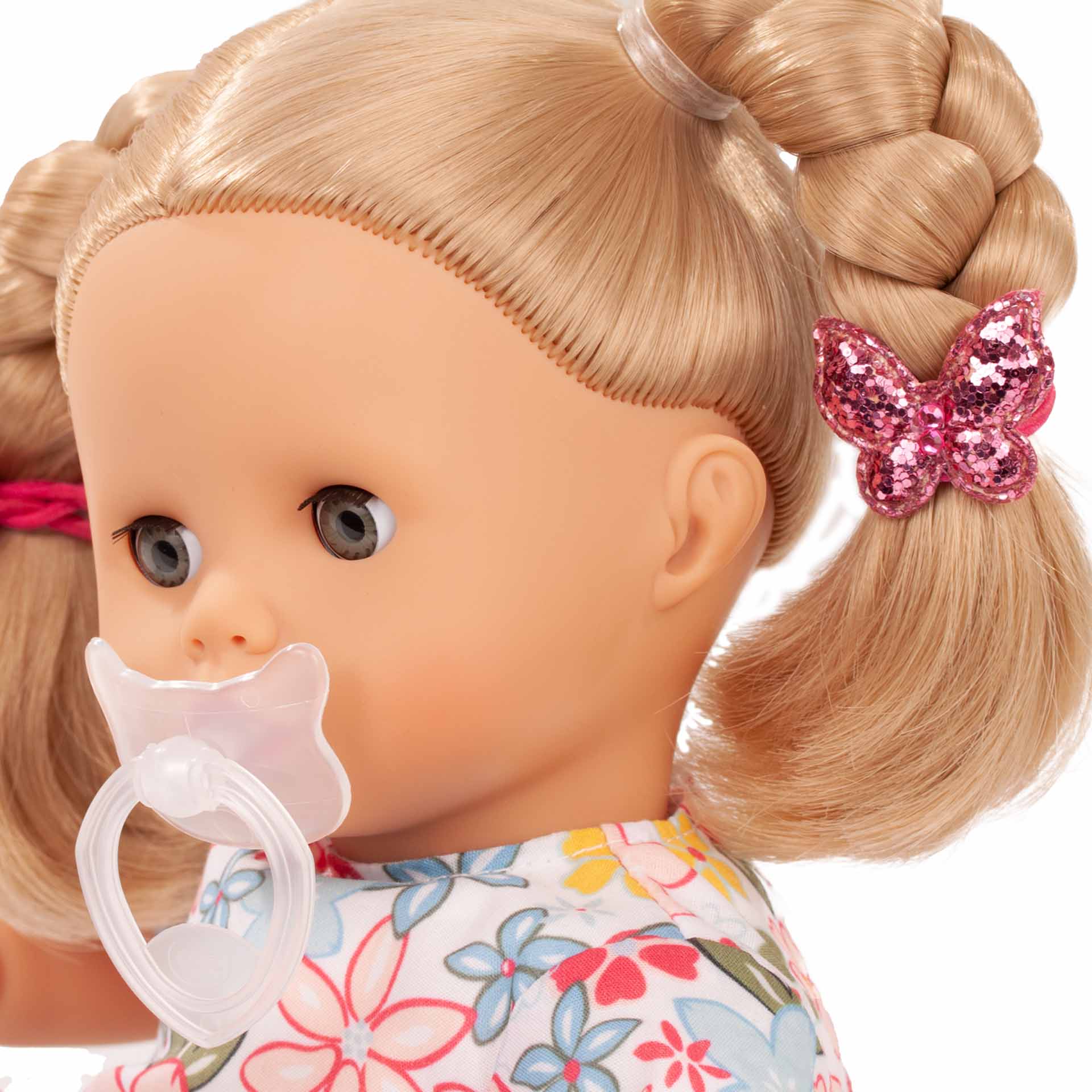 2120944-muffin-minimaxi-babypuppe-goetz-schnuller-portrait muffin-minimaxi-babypuppe-gesicht-schnuller-schlafaugen-blond-zoepfe-glitzerschmetterlin-zopfhalter-goetz
