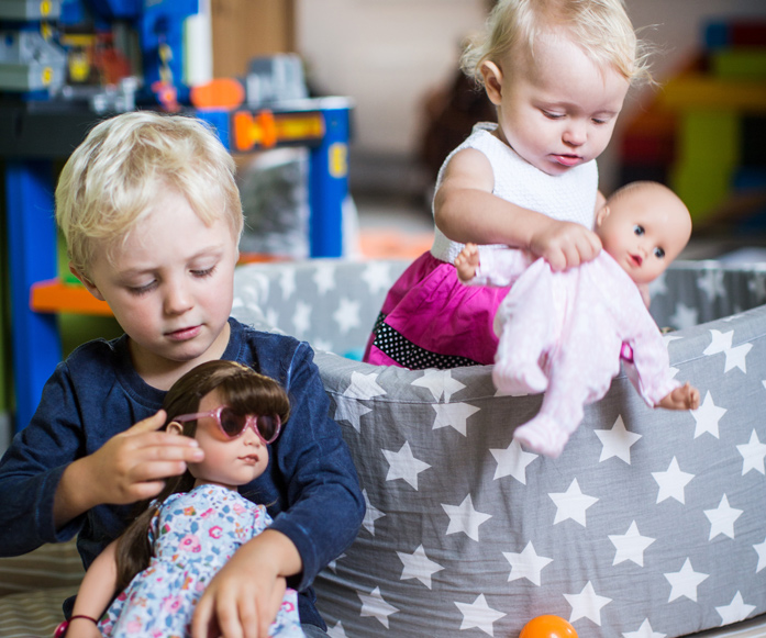 Zwei Kinder spielen mit Götz Puppen, einer Stehpuppe und einer babypuppe Muffin von Götz