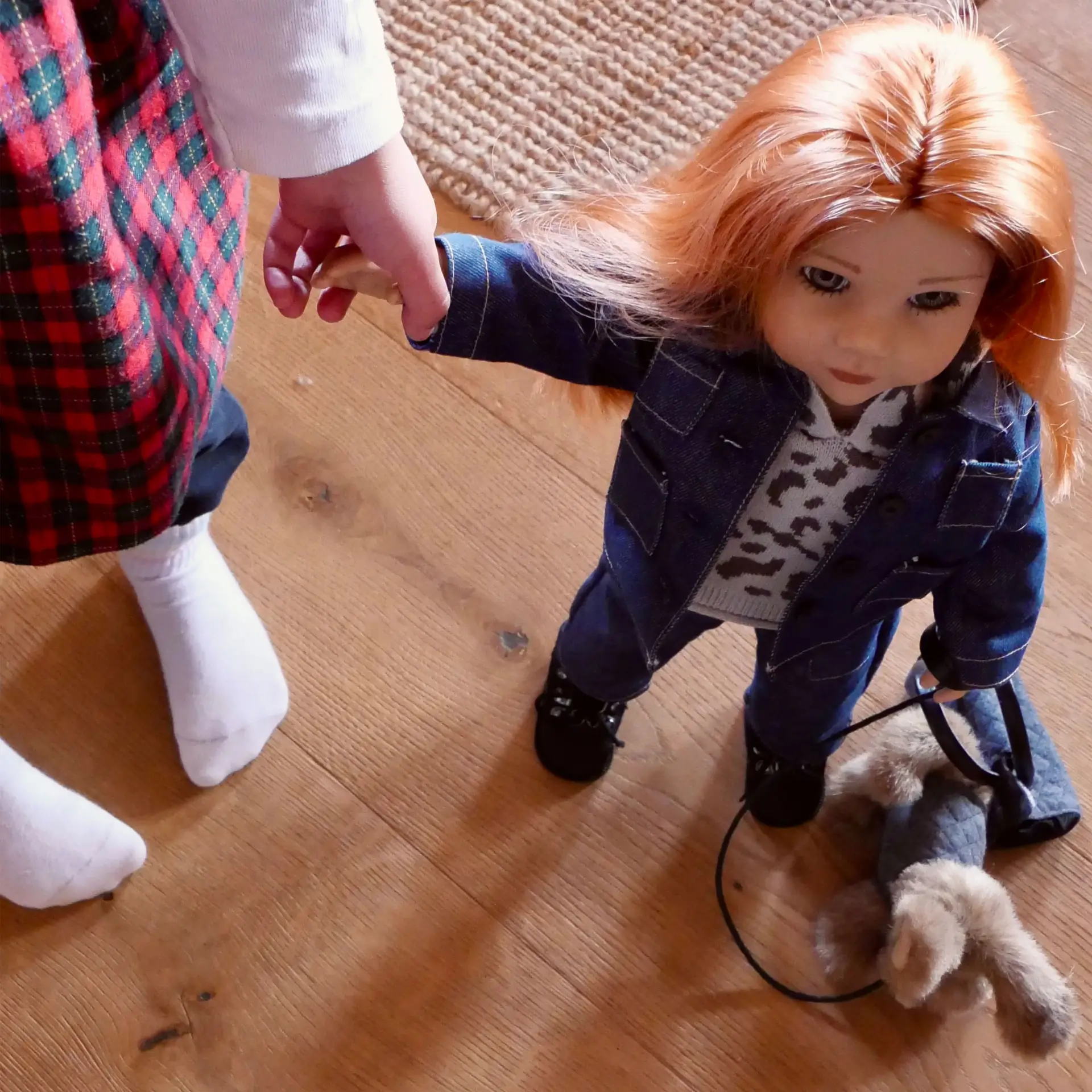 Kind haelt die Hand einer 50 cm grossen Stehpuppe mit langen roten Haaren und gruenen Augen, Jeanskombi und Strick-Hoodie im Leo-Design, brauner Hund mit Leine von Goetz