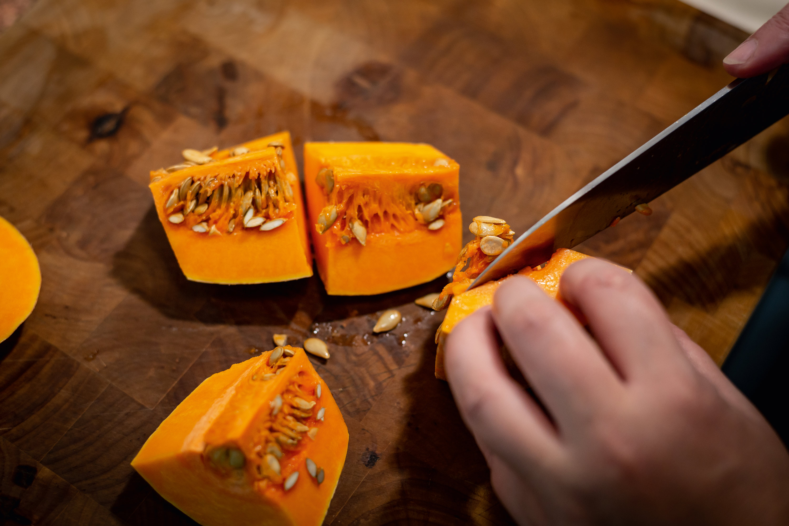 Kuerbis wird in kleine Stuecke geschnitten mit einem Messer