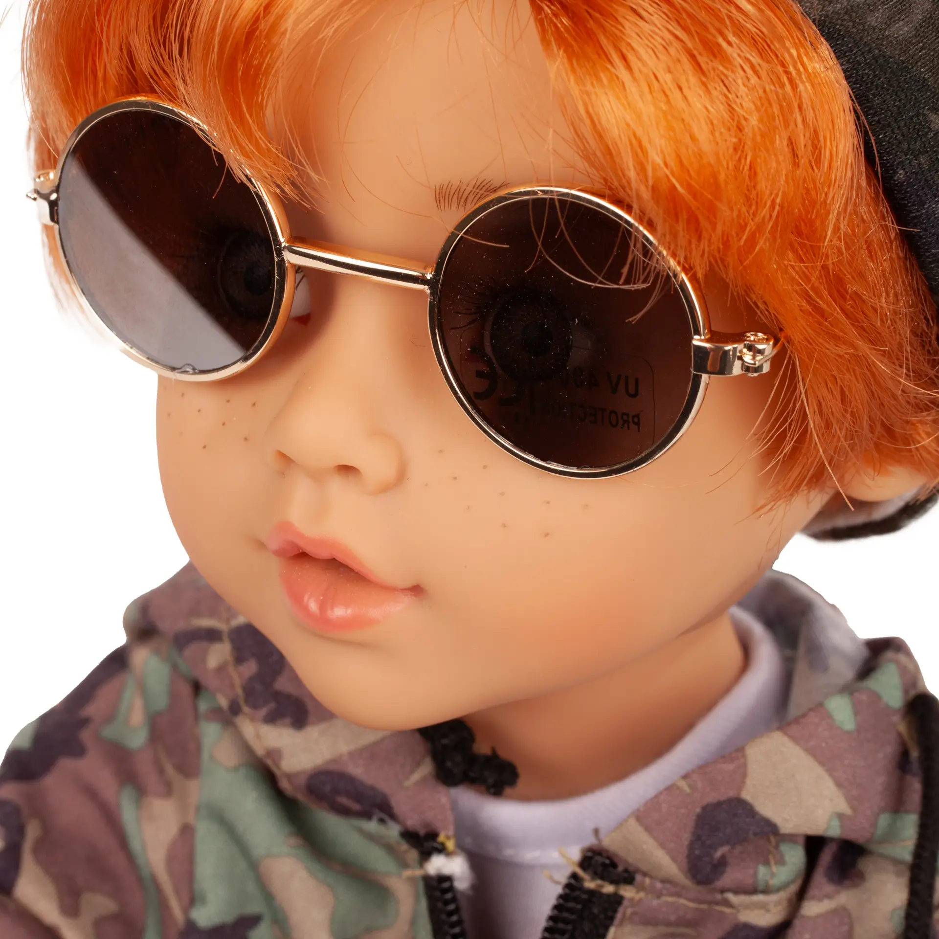 Portrait von Stehpuppe Gr. 36 cm mit rotem Haar, gruenen Augen und Sommersprossen. Er traegt eine goldene Nickelbrille von Goetz