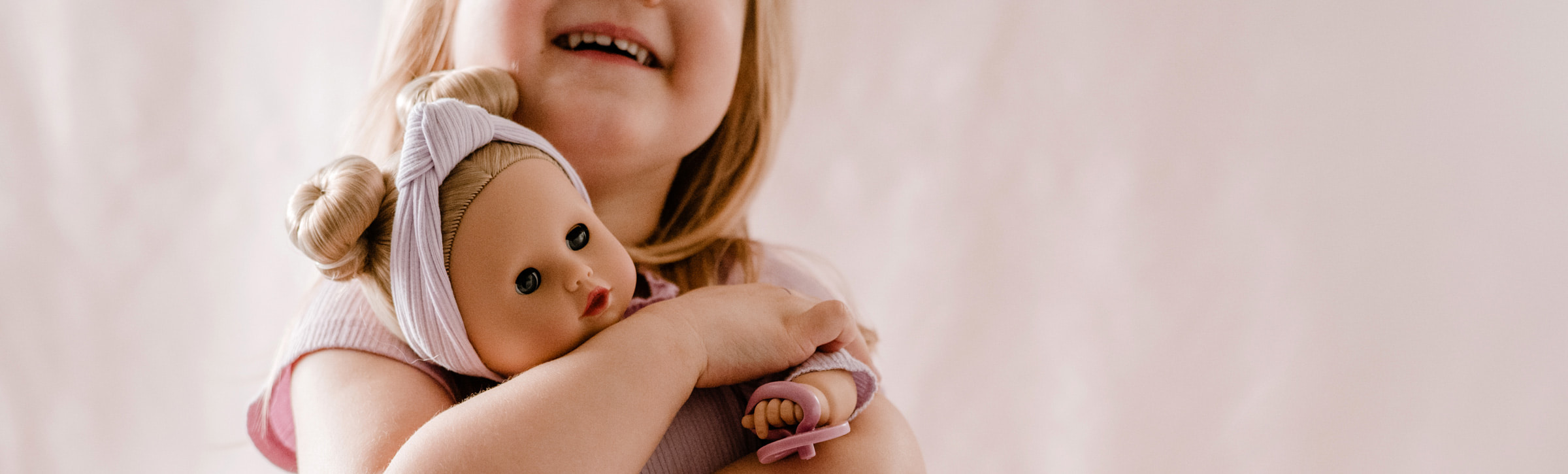 Kind-laechelt-eine-goetz-puppe-an-und-spielt