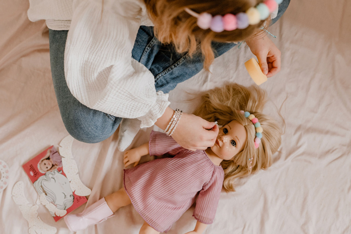 Hannah Be My Mini Me Goetz Kind spielt mit einer 50 cm grossen Stehpuppe mit blonden Haaren und rosa Kleid