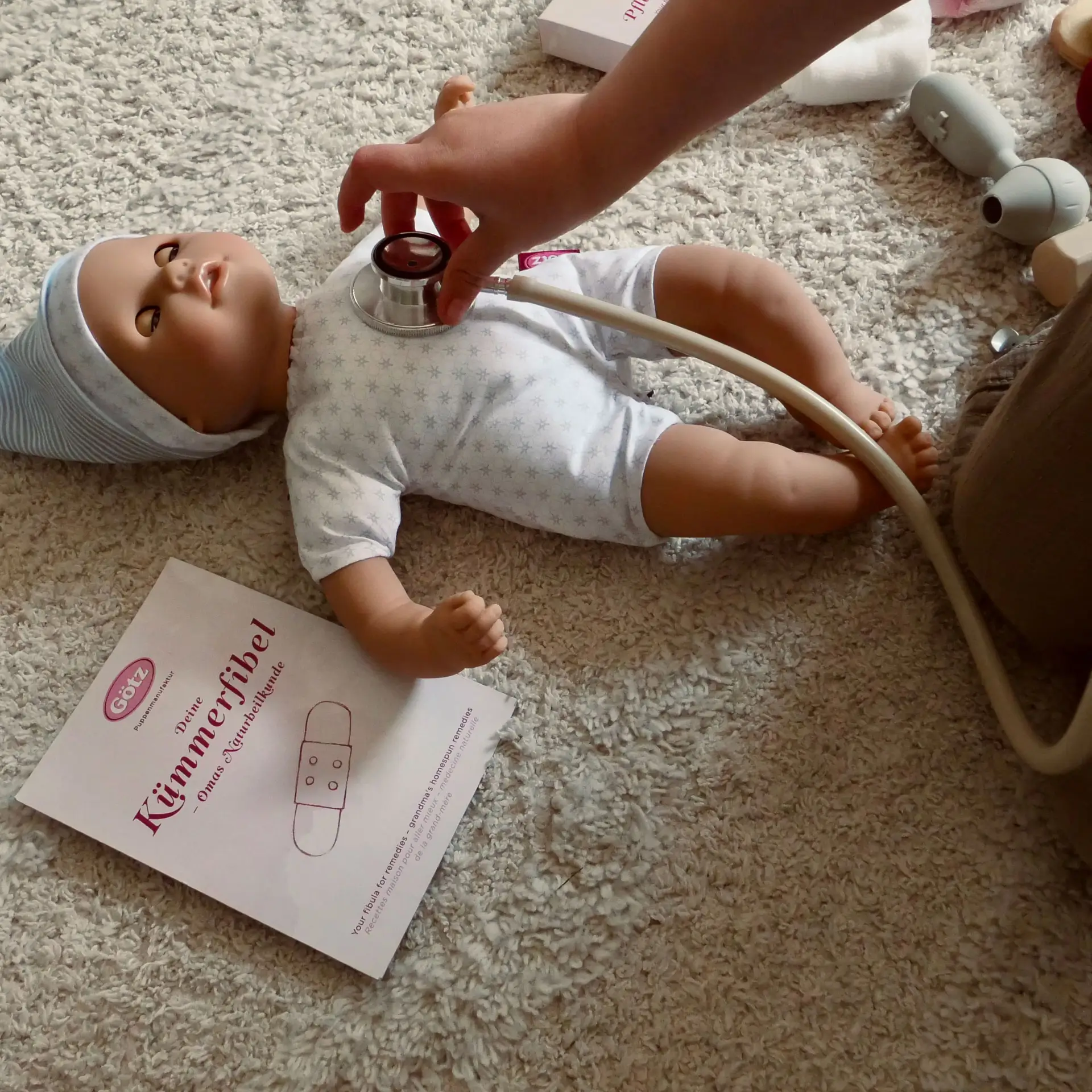 Kind hoert 33 cm grosse Babypuppe mit Schlafaugen mit einem Stethoskop ab