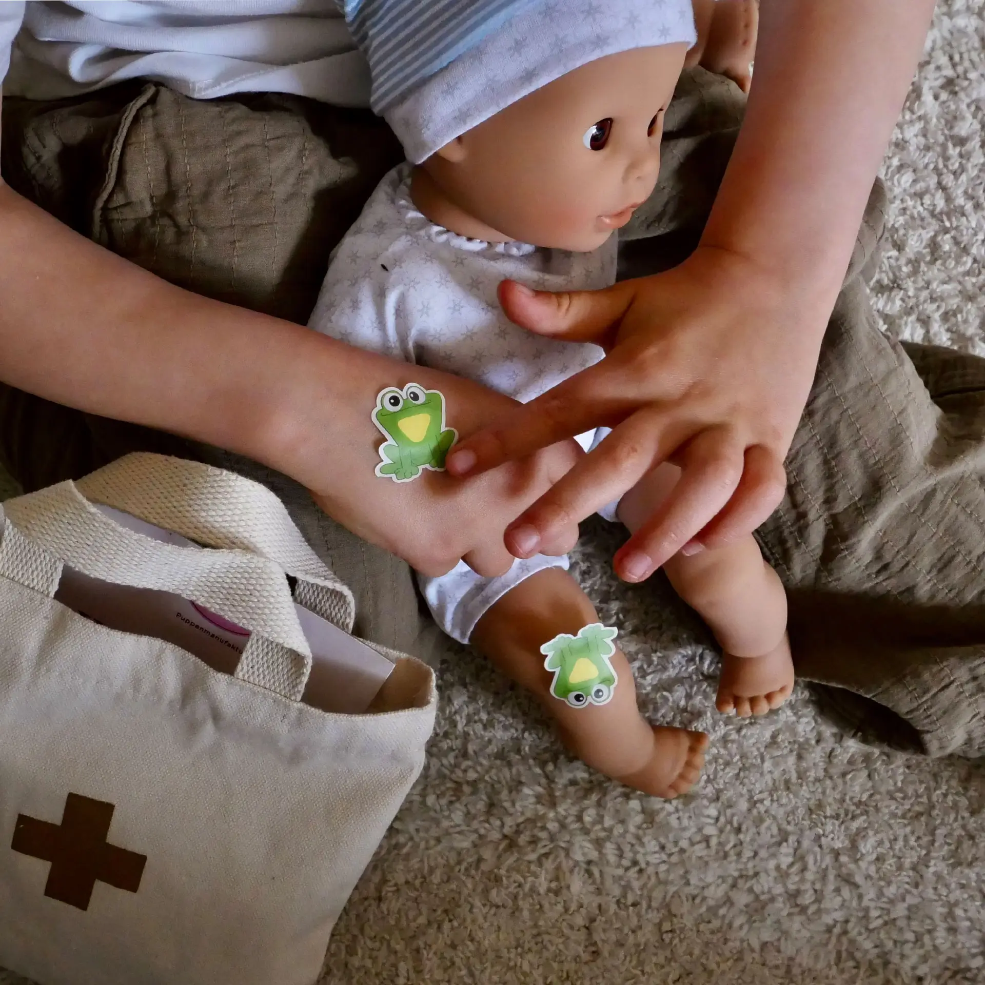 Kind spielt mit 33 cm grosser Babypuppe mit Schlafaugen, Arzttasche und Pflastern