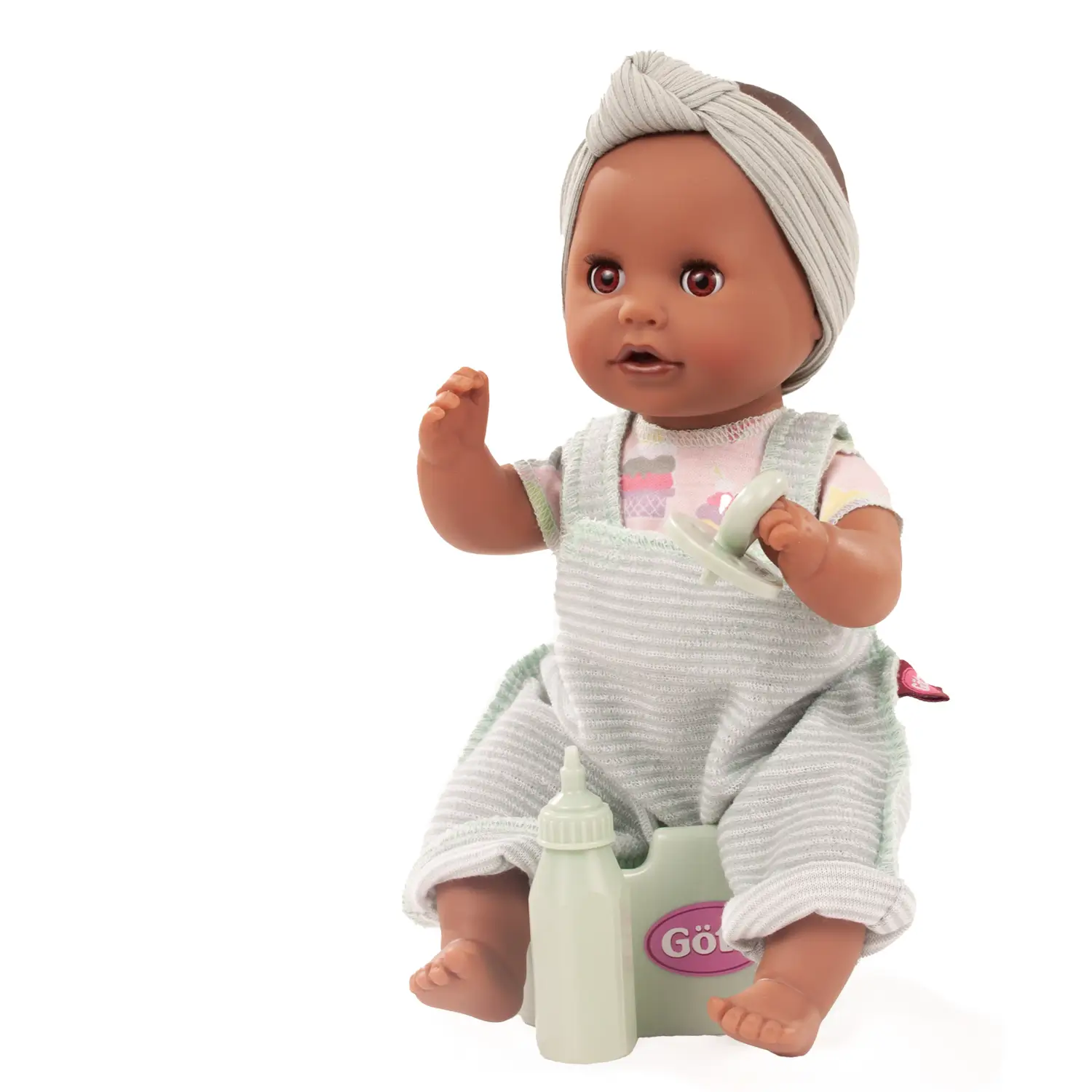 Badepuppe mit braunen Schlafaugen, ohne Haare in einem Frottee-Latzhose, T-shirt, Stirnband, Flaeschchen, Schnuller und Toepfchen von Goetz