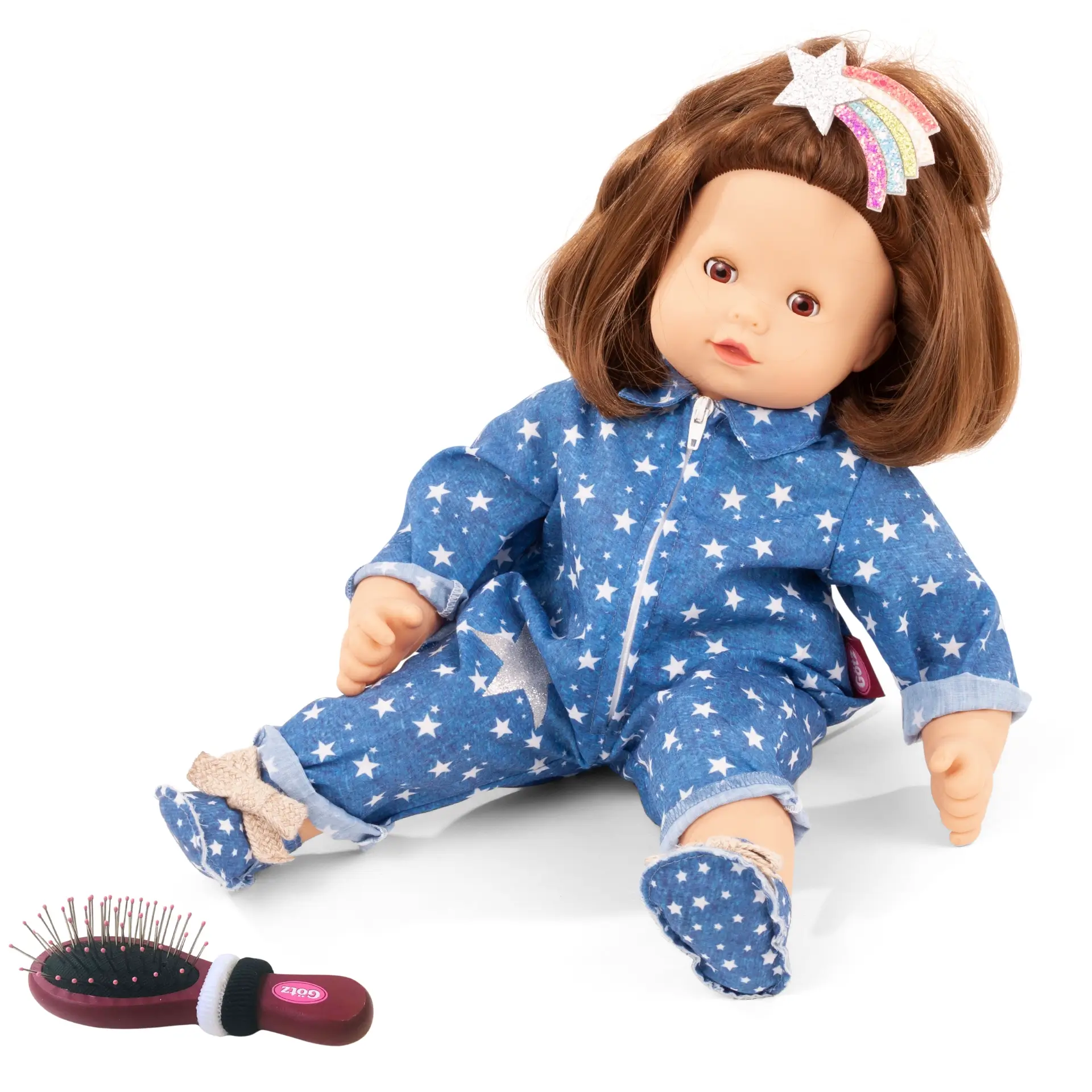 Babypuppe Gr. 42-46 cm mit braunen Haaren und braunen Schlafaugen. Dazu eine Buerste mit zwei Haargummis und einem Overall in blau mit Sternen und Stoffschuhen und einer Regenbogen-Haarspange von Goetz