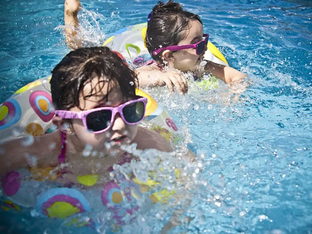 Schwimmen lernen mit Goetz Zwei Kinder schwimmen im Pool mit Schwimmring