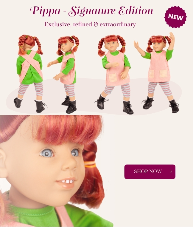 Multigelenkstehpuppe Signature Edition mit roten geflochtenen Zoepfen und blauen Augen. Sie traegt ein gruenes Langarmshirt mit organgefarbener Schuerze und eine geringelte Leggins, dazu schwarze Boots von Goetz