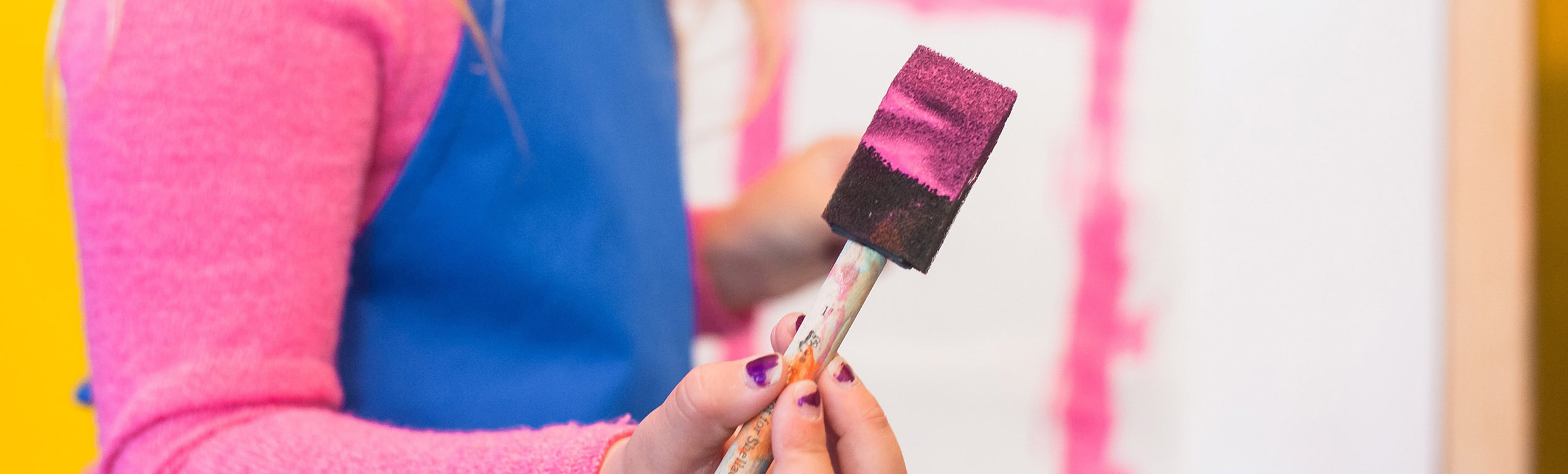 Kind hat einen Pinsel in der Hand um Puppenzubehör DYI zu machen